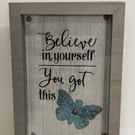 Framed rustic sign with “Believe in yourself You got this” text and a teal butterfly accent.