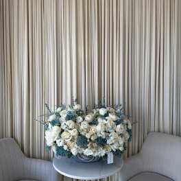 Large white and blue floral arrangement on a round table