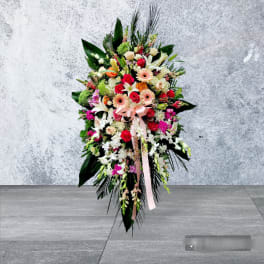Large standing floral spray with roses, lilies, and gerbera daisies