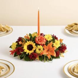 Autumn floral centerpiece with an orange taper candle