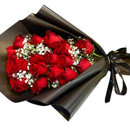 Bouquet of red roses wrapped in black paper with white baby's breath