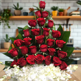 Tiered bouquet of red roses with white orchids in a basket