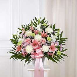 Pink and white floral arrangement with a pink ribbon in a vase