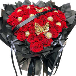 Heart-shaped bouquet of red roses with gold chocolates and black wrapping