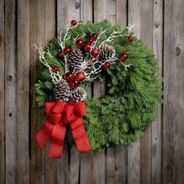 Christmas wreath with pinecones, red ornaments, and a red bow
