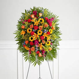 Standing floral spray with orange, yellow, and pink flowers on an easel