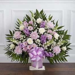 Standing floral spray with pink and white flowers and a lavender ribbon