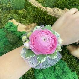 Pink flower wrist corsage with green leaves and tulle