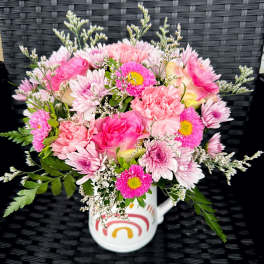 Pink mixed bouquet in a white mug with a rainbow design