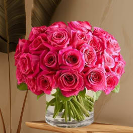 Bouquet of bright pink roses in a clear glass vase