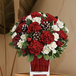 Red and white floral arrangement in a clear square vase