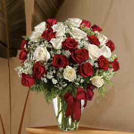 Red and white roses arranged in a clear glass vase