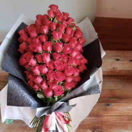Large bouquet of pink roses wrapped in black and white paper
