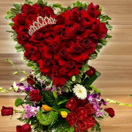 Heart-shaped bouquet of red roses with a jeweled tiara and ribbon