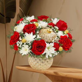 Red roses and white daisies in a gold vase