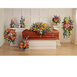 Colorful funeral casket spray with standing floral tributes