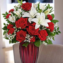 Red roses and white lilies arranged in a tall vase
