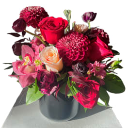 Bouquet of red and pink flowers in a black vase