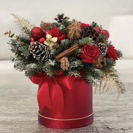Red roses and pinecones arranged in a red gift box