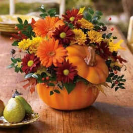 Pumpkin centerpiece with orange and burgundy flowers