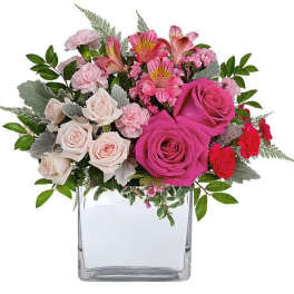 Pink and white rose bouquet in a clear square vase