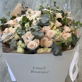 Bouquet of pale pink roses and eucalyptus in a white box