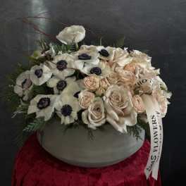 Cream and blush roses with white anemones in a round vase