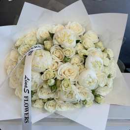 Bouquet of white roses and peonies wrapped in white paper
