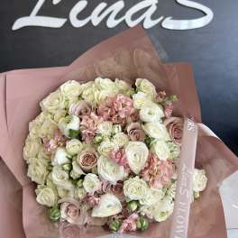 Large bouquet of cream and blush roses wrapped in pink paper