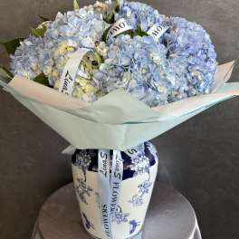 Bouquet of pale blue hydrangeas in a decorative vase