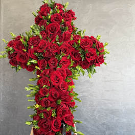 Large cross-shaped arrangement of red roses on a stand