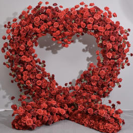 Heart-shaped floral display of red roses and small red blooms