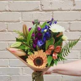 Mixed bouquet with a sunflower, lilies, and purple flowers
