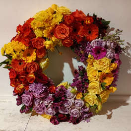Colorful floral wreath with roses, gerbera daisies, and chrysanthemums