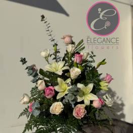 Tall bouquet of pink and white roses with lilies in a vase