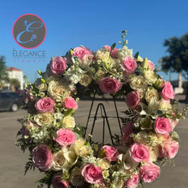 Large pink and white rose wreath on a black stand