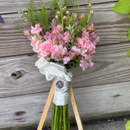Pink bouquet with roses and alstroemeria tied with a white ribbon