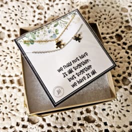 Gift box with two puzzle-piece necklaces and a printed card