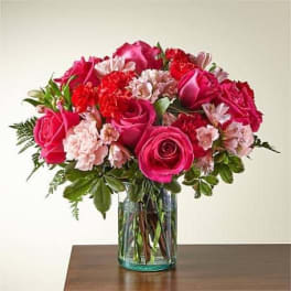 Pink roses and carnations in a clear glass vase