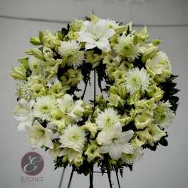 White and pale green floral wreath on a stand