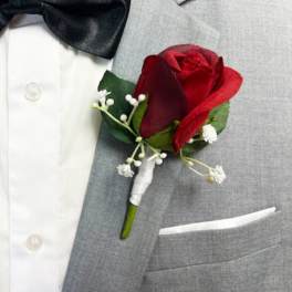 Red rose boutonniere on a gray suit jacket