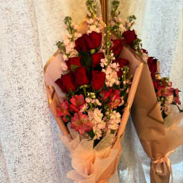 Bouquets of red roses and pink flowers wrapped in peach paper