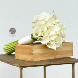 White calla lily bouquet beside a wooden box