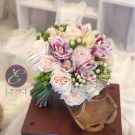 Bouquet of pale pink and white roses in a wooden boot-shaped container
