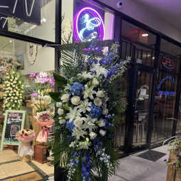 Tall blue and white floral standing arrangement on an easel