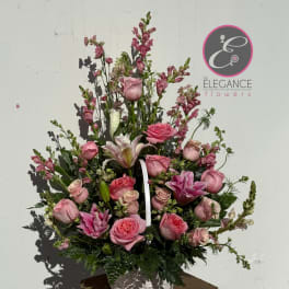 Pink roses and lilies arranged in a white basket