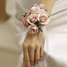 Pink rose wrist corsage with ribbon on a hand