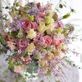 Pastel bouquet of pink and cream roses with lavender accents