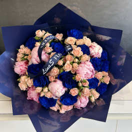 Bouquet of blue and blush roses wrapped in dark blue paper