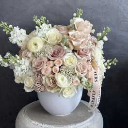 Blush and white rose bouquet in a white vase